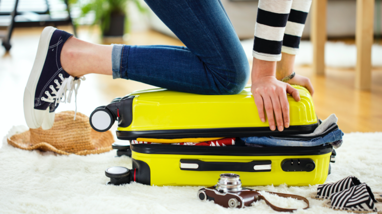 Tipps Packen fürs Handgepäck Frau mit vollem Koffer Reisen123RF