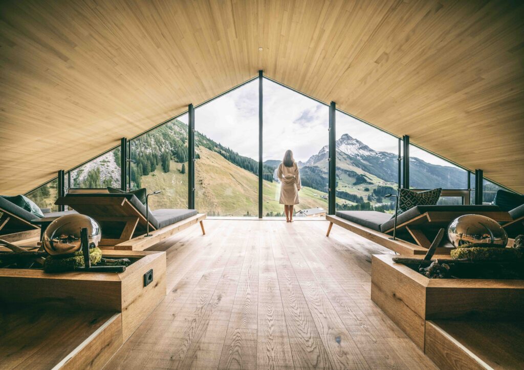 WARTHER HOF Frau im Bademantel vor Panoramafenster